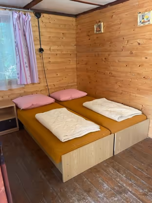 Interiér dřevěné chatky, obytná kuchyně s lůžky